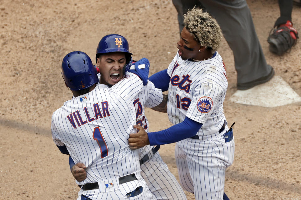 New York Mets' Javier Baez celebrates with Jonathan Villar and Francisco Lindor, right, after scoring the game winning run against the Miami Marlins during the ninth inning of the first game of a baseball doubleheader that started April 11 and was suspended because of rain, Tuesday, Aug. 31, 2021, in New York. The Mets won 6-5. (AP Photo/Adam Hunger)