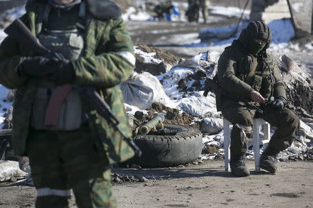 A fighter with the separatist self-proclaimed Donetsk People's Republic Army sits at a checkpoint along a road from the town of Vuhlehirsk to Debaltseve in Ukraine, in this picture taken February 18, 2015. REUTERS/Baz Ratner