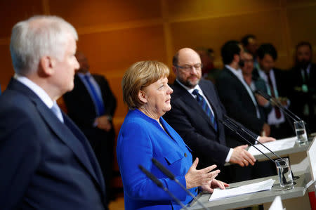 Acting German Chancellor Angela Merkel, leader of the Christian Social Union in Bavaria (CSU) Horst Seehofer and Social Democratic Party (SPD) leader Martin Schulz attend a news conference after exploratory talks about forming a new coalition government at the SPD headquarters in Berlin, Germany, January 12, 2018. REUTERS/Hannibal Hanschke
