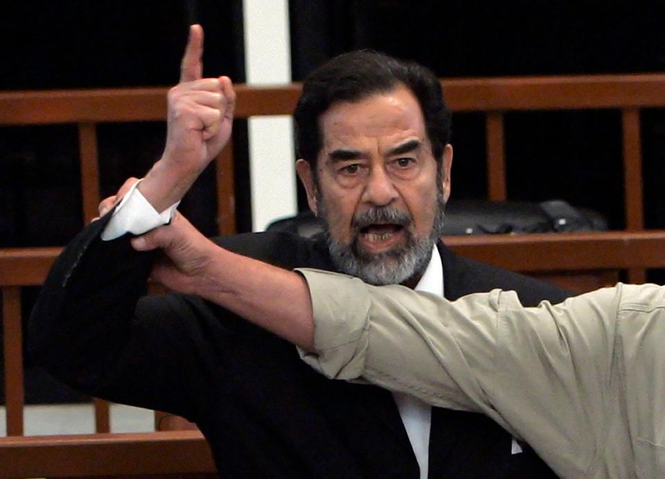 Former Iraqi President Saddam Hussein yells at the court as a bailiff attempts to silence him as the verdict is delivered during his trial on Nov. 5, 2006. Iraq's High Tribunal found Saddam Hussein guilty of crimes against humanity and sentenced him to die by hanging.