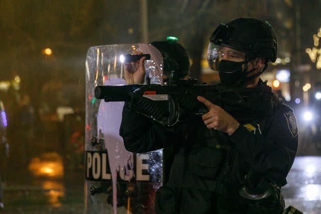 A Portland police officer uses tear gas as people gather to protest police brutality near the federal courthouse on Dec. 31, 2020.