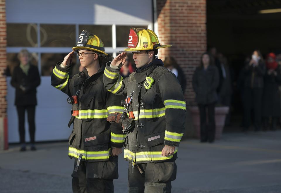 Two Firefighters salute at Grove Street Fire Station, after putting the flag at half staff after Lt. Jason Menard died in an overnight fire Wednesday, Nov. 13, 2019 in Worcester, Mass. Menard, 39, and his crew became trapped on the top floor of the three-story home after the fire was reported at about 1 a.m., Worcester Fire Chief Michael Lavoie told a news conference. Menard helped two members of his crew escape but he himself was unable to get out. (Christine Peterson/Worcester Telegram & Gazette via AP)