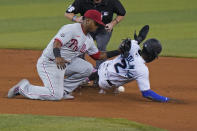 Philadelphia Phillies shortstop Jean Segura, left, is unable to hang on to the throw as Miami Marlins' Jazz Chisholm Jr. steals second base during the first inning of a baseball game, Tuesday, May 25, 2021, in Miami. (AP Photo/Wilfredo Lee)