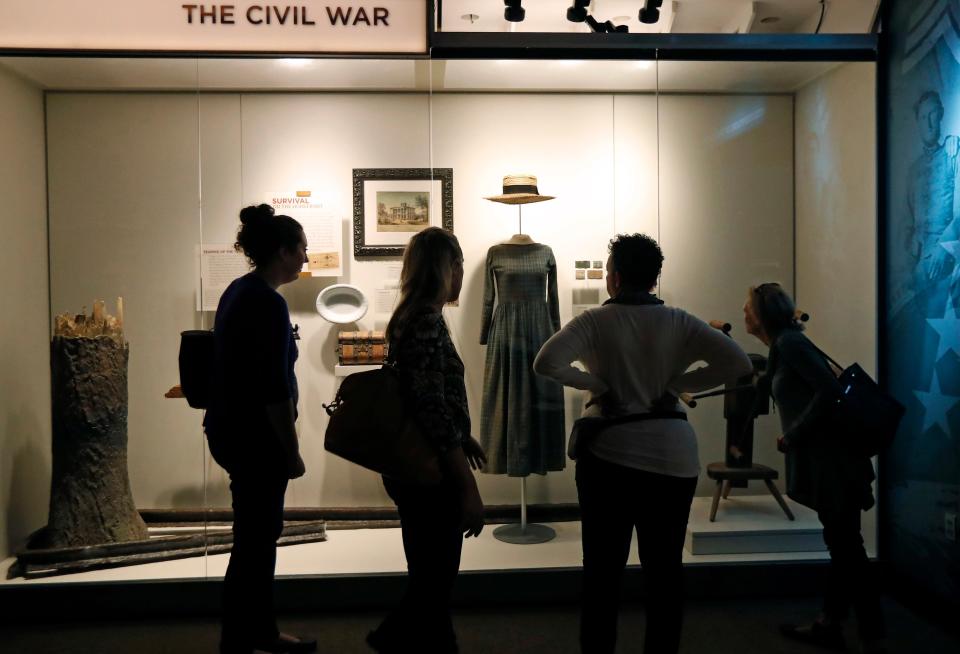 Visitors to the Museum of Mississippi History in Jackson examine examples of clothing in the Civil War gallery.