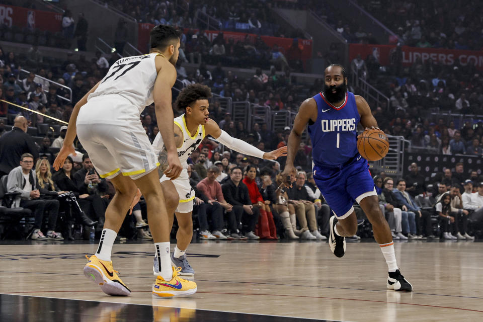 Los Angeles Clippers guard James Harden (1) driveds past Utah Jazz guard Keyonte George and center Omer Yurtseven (77) during the first half of an NBA basketball game Friday, April 5, 2024, in Los Angeles. (AP Photo/Etienne Laurent)
