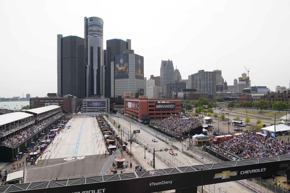 Fans watch the IndyCar Detroit Grand Prix auto race next to the split pit lanes, Sunday, June 4, 2023, in Detroit. (AP Photo/Carlos Osorio)