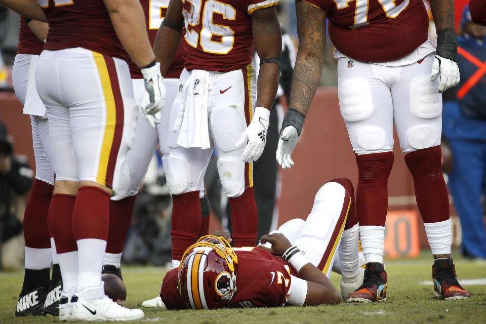 Washington Redskins quarterback Dwayne Haskins, bottom, lies on the ground after being sacked by New York Giants linebacker Lorenzo Carter, not visible, during the second half of an NFL football game, Sunday, Dec. 22, 2019, in Landover, Md. Haskins walked to a cart and was taken off the field after the play. (AP Photo/Patrick Semansky)