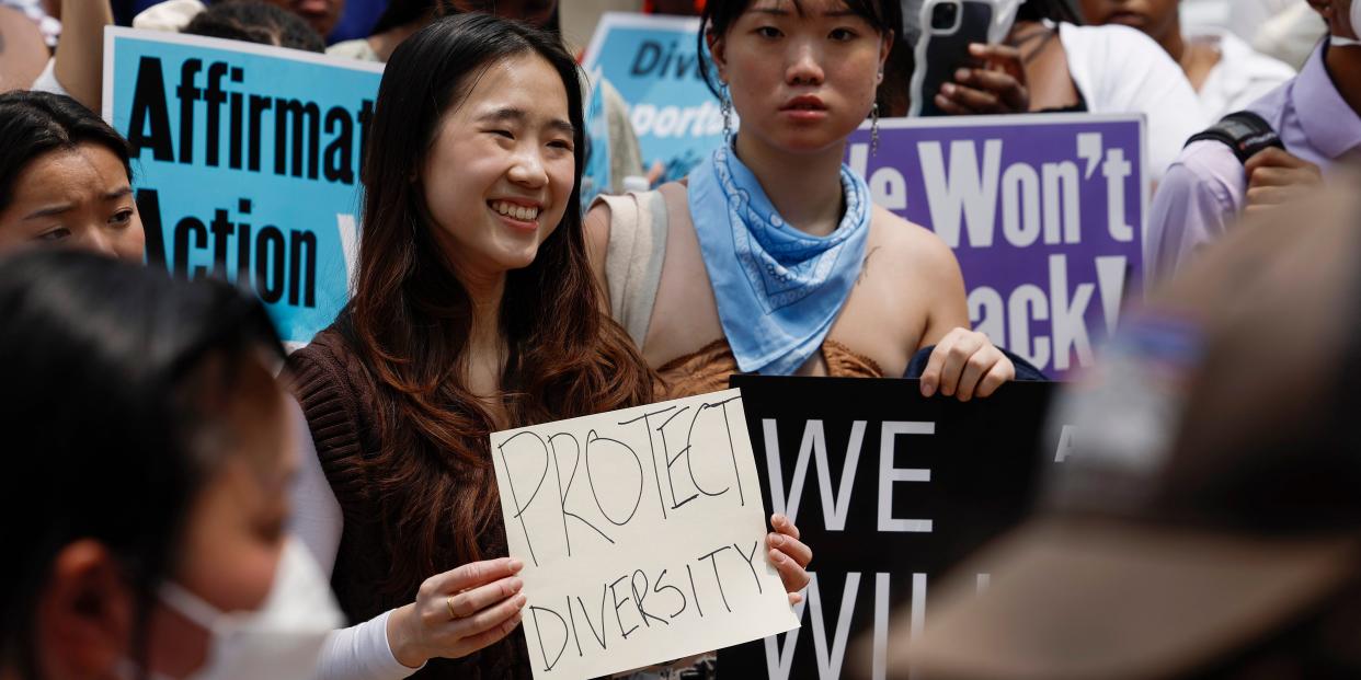 woman at protest holding sign that says "protect diversity"