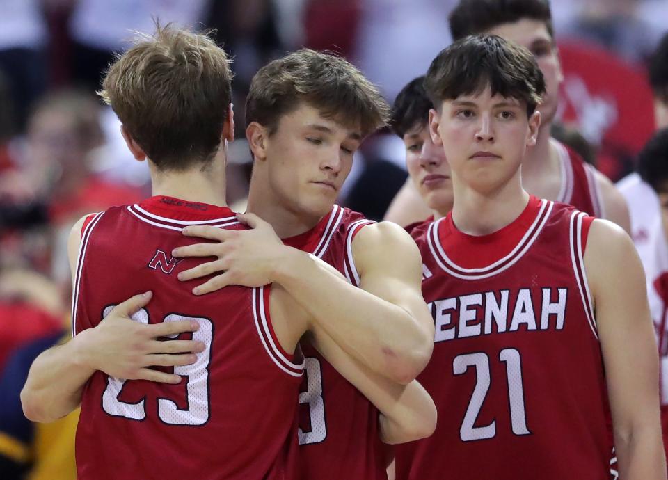 Neenah's Charlie Wunderlich (23) and Grant Dean (13) embrace following the Rockets' loss to Hartland Arrowhead in a Division 1 semifinal game during the WIAA state boys basketball tournament Friday at the Kohl Center in Madison.