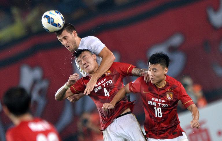 Nikita Rukavytsya (C) of Australia's Western Sydney Wanderers tussles for the ball against Zhang Jiaqi of China's Guangzhou Evergrande during their AFC Champions League group H first round match in Guangzhou China on May 5, 2015