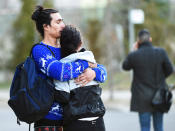 <p>Two people comfort each other after a rented van plowed down a crowded sidewalk, killing multiple people and injuring others before the driver fled and was quickly arrested in a confrontation with police, according to authorities, Monday, April 23, 2018, in Toronto. (Photo: Nathan Denette/The Canadian Press via AP) </p>
