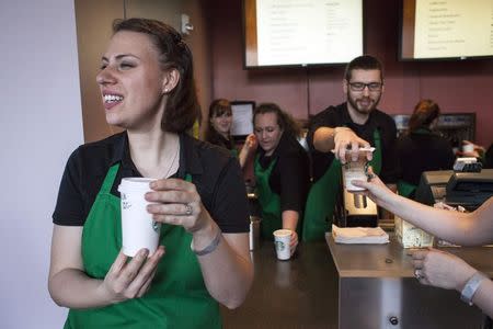Starbucks baristas serve coffee during the company's annual shareholder's meeting in Seattle, March 18, 2015. REUTERS/David Ryder