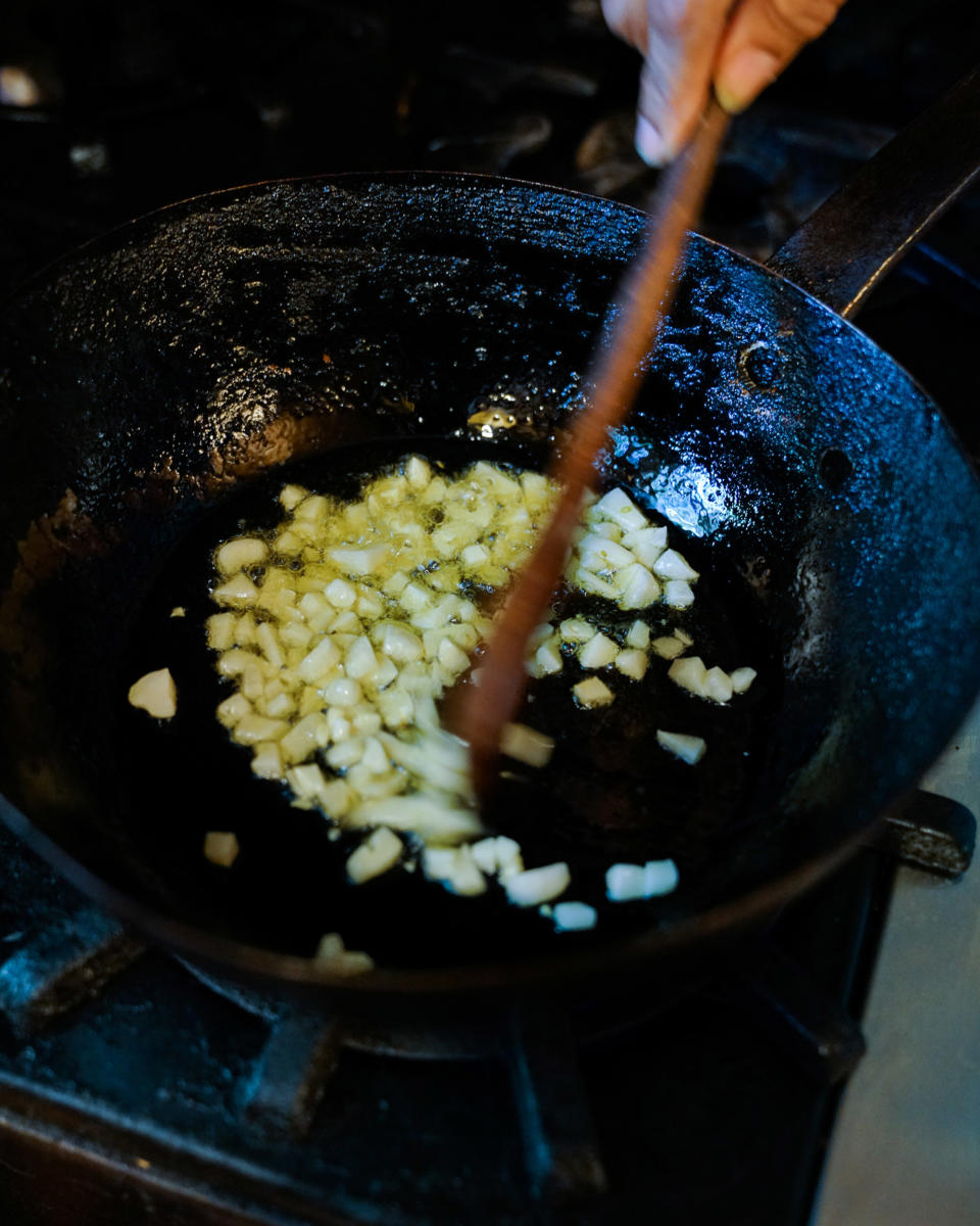 After warming the olive oil, Harris cooks the garlic, stirring constantly, until very fragrant. (Kara Birnbaum / TODAY)