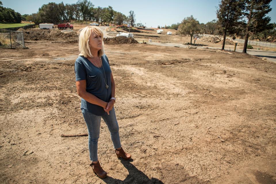 Santa Rosa resident Paula Lindsay, 56, who lost her home in the 2017 Tubbs wildfire, stands in a lot at the Oaks at Fountaingrove development that was leveled by fire. Rebuilding began with a year.