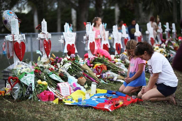 People visit a makeshift memorial in front of Marjory Stoneman Douglas High School in Parkland, Florida