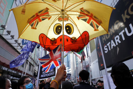 A pro-independence supporter raises a umbrella with British flags as she takes part in an annual New Year's Day march in Hong Kong, China January 1, 2019. REUTERS/Tyrone Siu