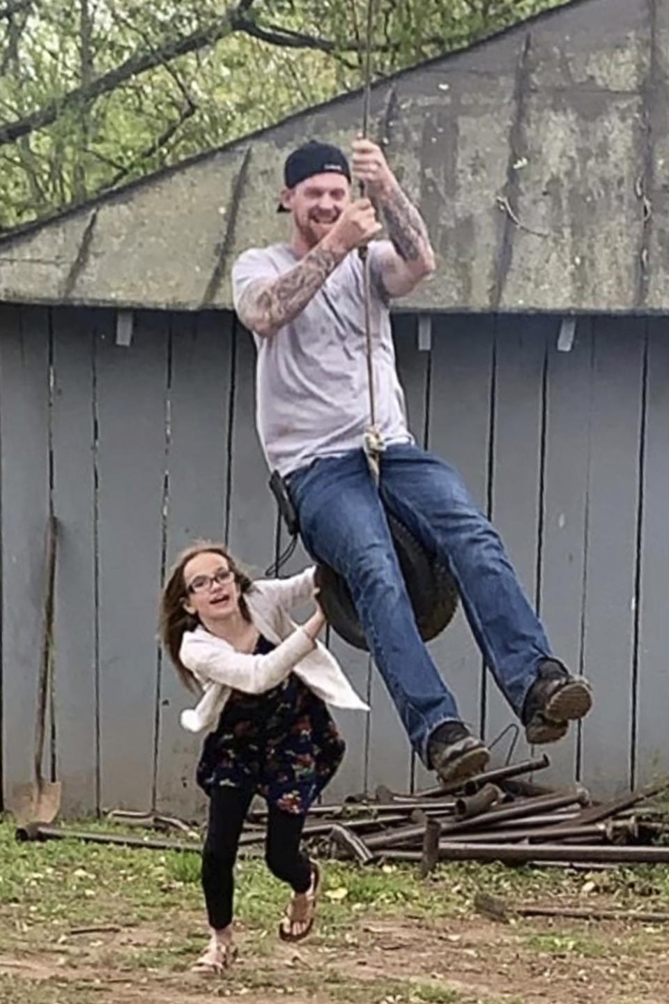 This undated photo provided by the family of Matt Jones shows him, right, and his niece playing on a tire swing at his brother Mark Jones' house in Culpeper, Va. Jones, a 36-year-old man from West Virginia, was apparently suffering from a severe manic episode on July 6, 2022, while standing on a highway Bradley, W.Va., with a handgun. The scene was captured by a bystander on video. One officer took a shot and then others opened fire, killing Jones in a hail of bullets. Jones had been unable to get his medication refilled and was experiencing delusions and hallucinations, his fiancée said. (Family of Matt Jones via AP)