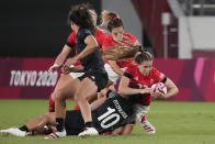 Britain's Holly Aitchison, right, is tackled by New Zealand's Theresa Fitzpatrick, bottom, in their women's rugby sevens match at the 2020 Summer Olympics, Thursday, July 29, 2021 in Tokyo, Japan. (AP Photo/Shuji Kajiyama)