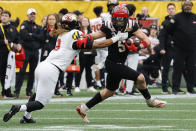 North Carolina State wide receiver Thayer Thomas, right, fights for yardage after a catch as Maryland linebacker Fa'Najae Gotay reaches in during the first half of the Duke's Mayo Bowl NCAA college football game in Charlotte, N.C., Friday, Dec. 30, 2022. (AP Photo/Nell Redmond)