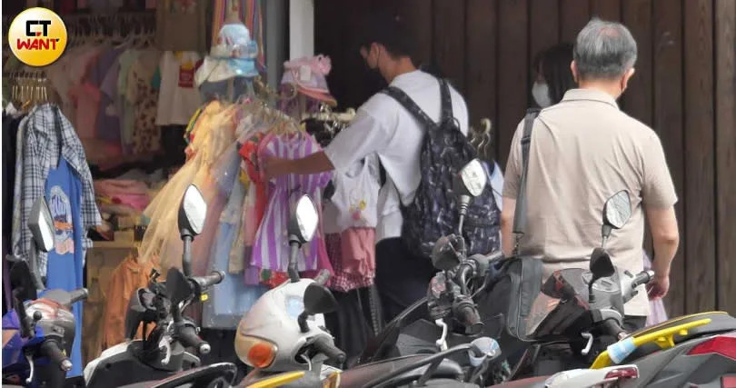 經過販售童裝的商店，江宏傑還特別停下腳步並伸手拿著一件童裝打量半天，十足好爸爸樣子。（圖／本刊攝影組）