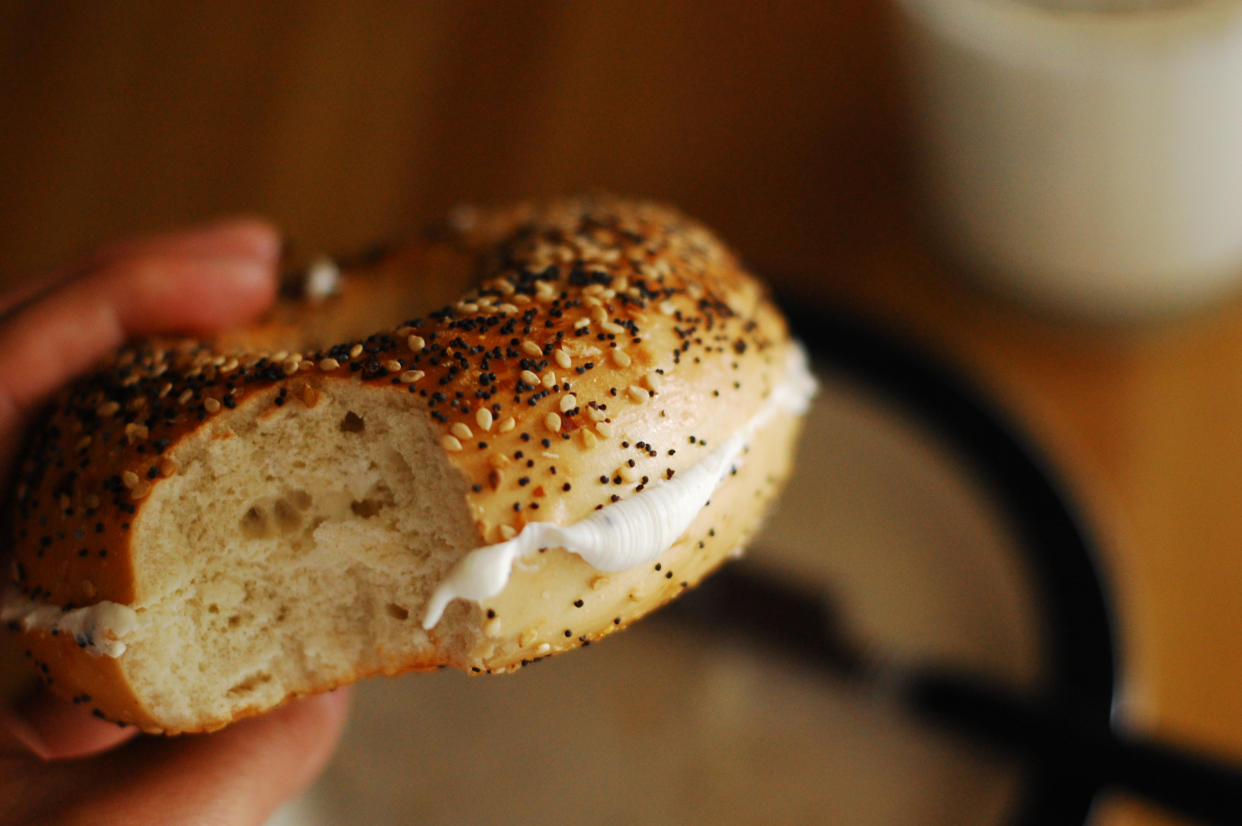 An everything bagel with a schmear of cream cheese.
