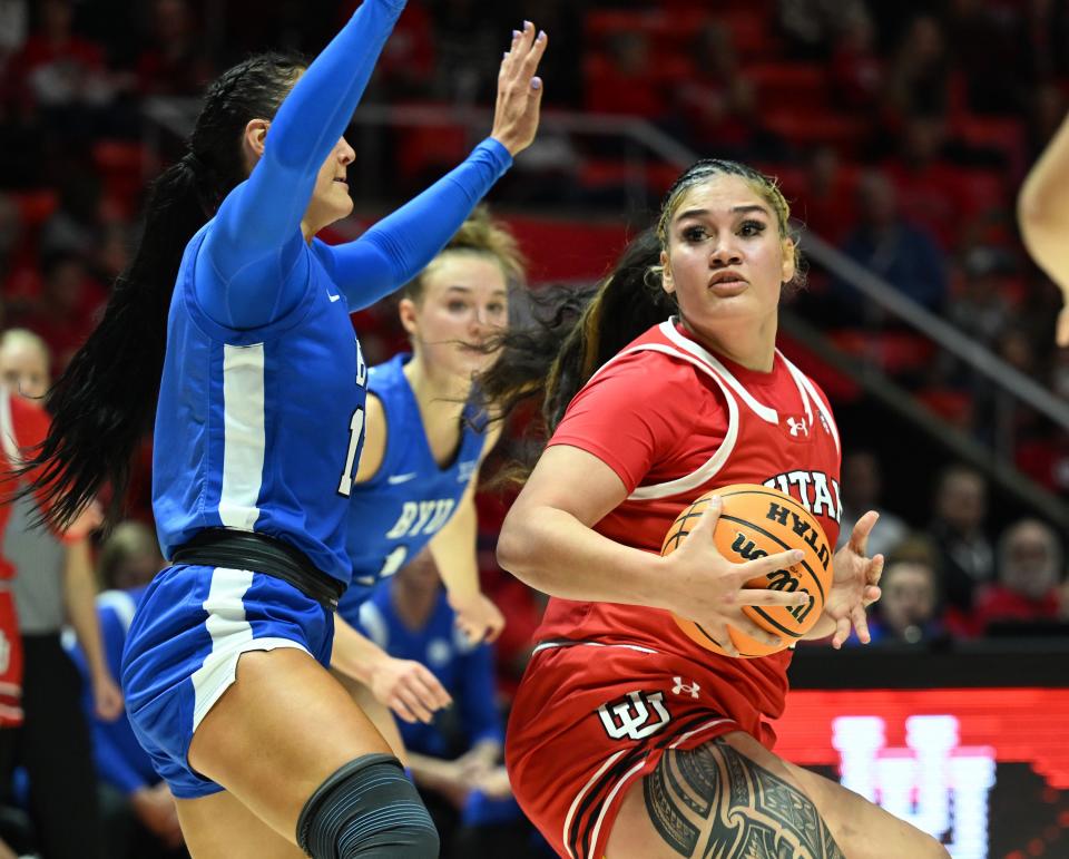Utah Utes forward Alissa Pili (35) looks one way and goes the other on BYU Cougars forward Lauren Gustin (12) as Utah and BYU women play at the Huntsman Center in Salt Lake City on Saturday, Dec. 2, 2023.