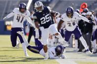 BYU running back Tyler Allgeier (25) runs the ball for a first down past North Alabama cornerback Will Singleton, bottom, defensive end Tyler Antkowiak (41) and linebacker Christon Taylor (25) in the second quarter during an NCAA college football game Saturday, Nov. 21, 2020, in Provo, Utah. (AP Photo/Jeff Swinger, Pool)
