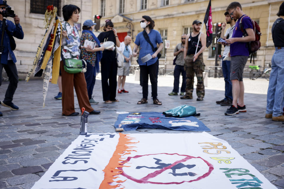 Activists display a banner which reads "Let's extinguish the flame" as they protest against the Paris 2024 Olympic games near the Pantheon in Paris, Friday, June 23, 2023. French police searched the Paris Olympic organizers' headquarters on Tuesday, June 20, 2024 as part of corruption investigations into contracts linked to the Games, according to prosecutors, the third straight time graft allegations have dogged a Summer Olympics. (AP Photo/Thomas Padilla)