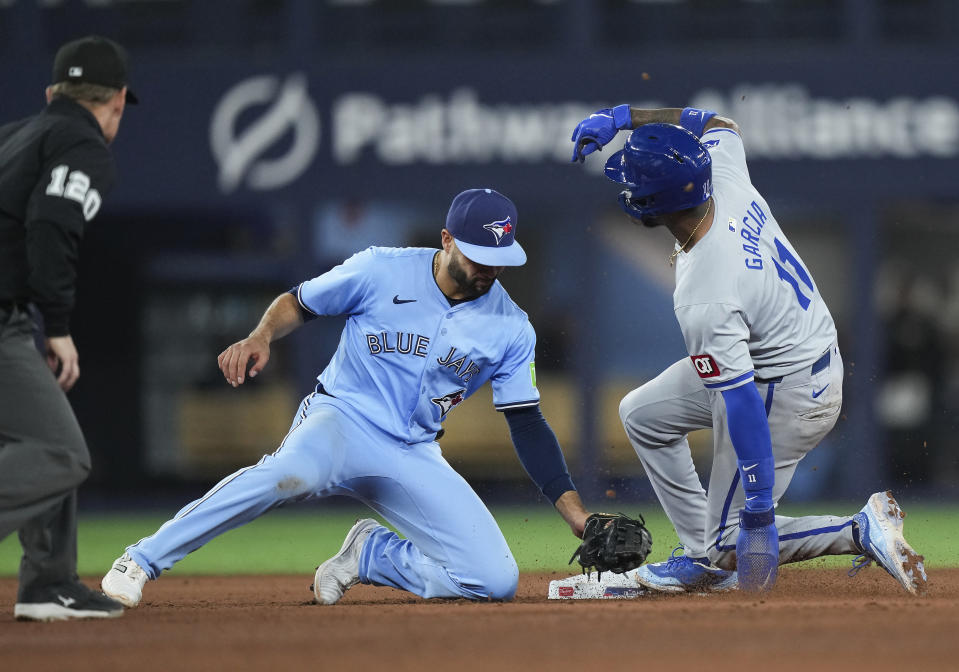 Kansas City Royals' Maikel Garcia (11) steals second base past Toronto Blue Jays second baseman Isiah Kiner-Falefa (7) during the eighth inning of a baseball game, Tuesday, April 30, 2024 in Toronto.(Nathan Denette/The Canadian Press via AP)