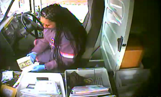 Surveillance photo of postal carrier Marlene Cruz taking cash from a greeting card.