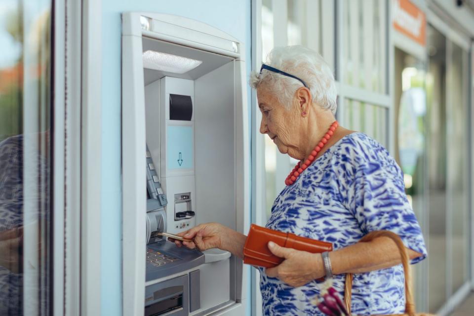 A person inserts a card into an ATM.