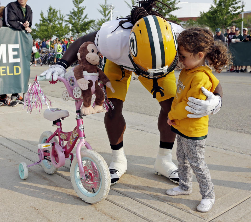 Green Bay Packers’ DuJuan Harris hugs a fan before NFL football training camp Monday, July 28, 2014, in Green Bay, Wis. (AP Photo/Morry Gash)