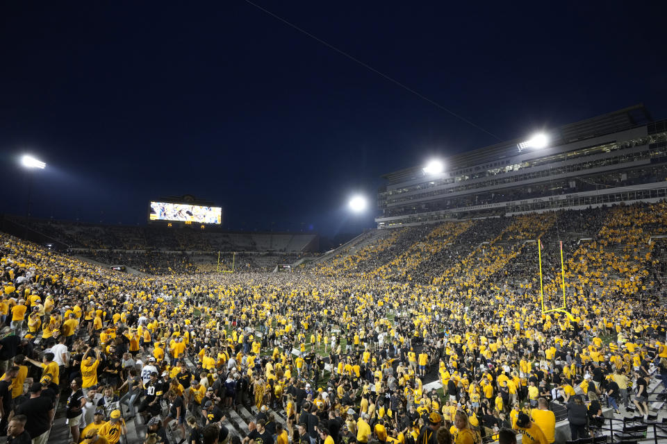 Fans storm the field after Iowa beat Penn State 23-20, in an NCAA college football game, Saturday, Oct. 9, 2021, in Iowa City, Iowa. (AP Photo/Matthew Putney)