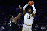 Villanova's Eric Dixon, right, shoots the ball past Providence's Ed Croswell during the first half of an NCAA college basketball game, Sunday, Jan. 29, 2023, in Philadelphia. (AP Photo/Derik Hamilton)