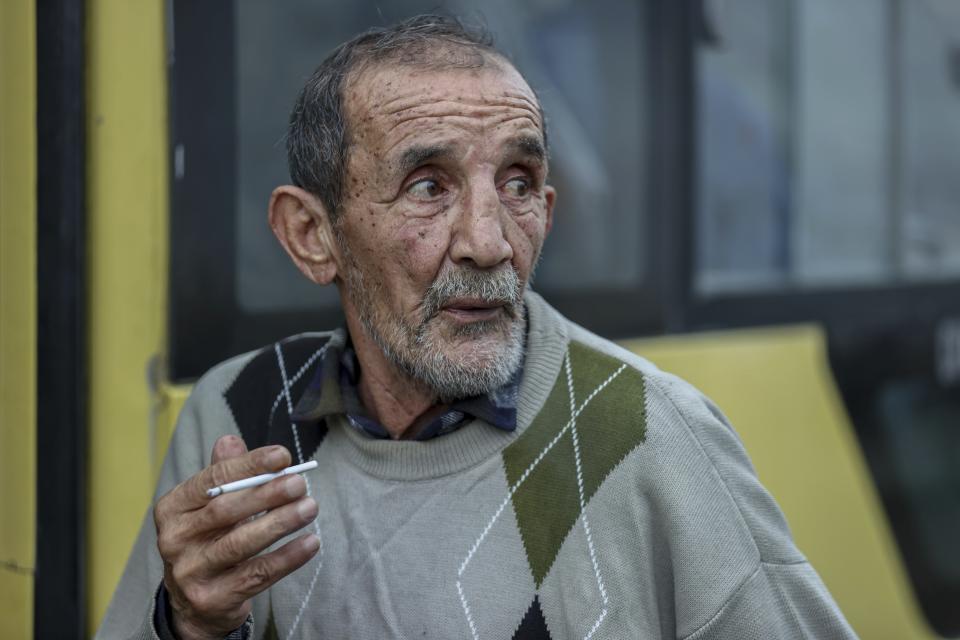 A ethnic Armenian man from Nagorno-Karabakh smoke a cigarette waiting to take a bus to drive to Armenia's Goris, in Lissagorsk village, Azerbaijan, Sunday, Oct. 1, 2023. The last bus carrying ethnic Armenians from Nagorno-Karabakh has left the region, completing a weeklong, grueling exodus in which more than 80% of its residents have fled after Azerbaijan reclaimed the area in a lightning military operation. (AP Photo/Aziz Karimov)