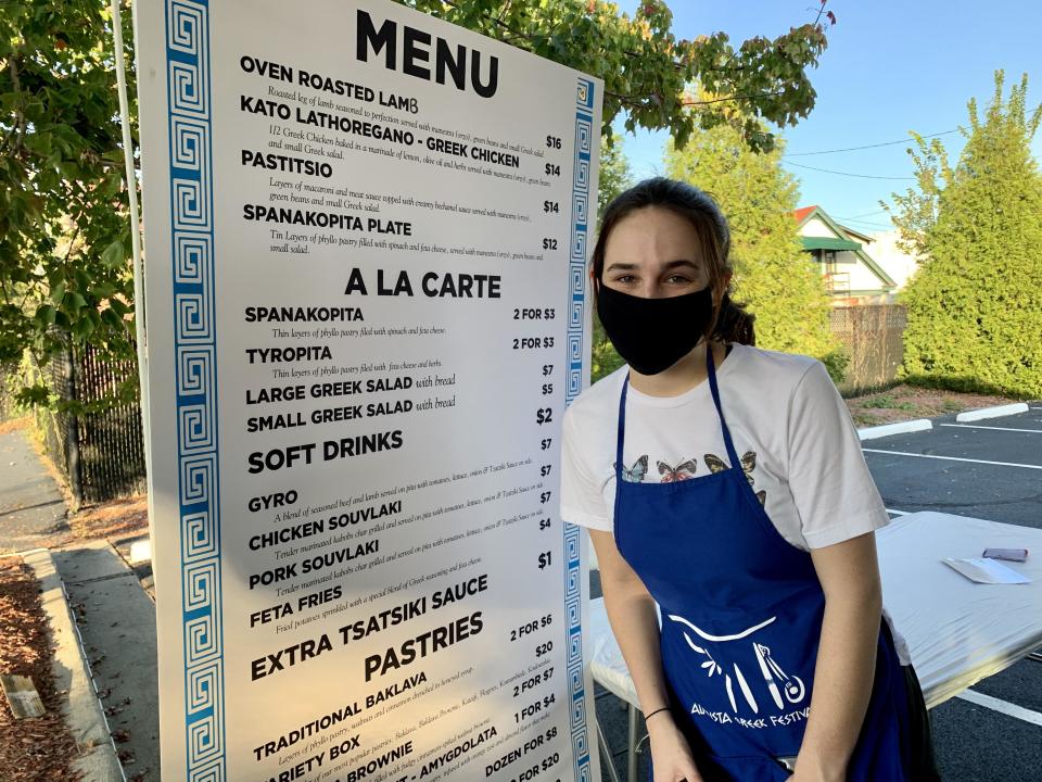 Kallit Stewart, 19, takes customers' orders in the parking lot of Holy Trinity Greek Orthodox Church on opening night October 2, 2020, for the Greek Festival drive-thru in Augusta, GA.