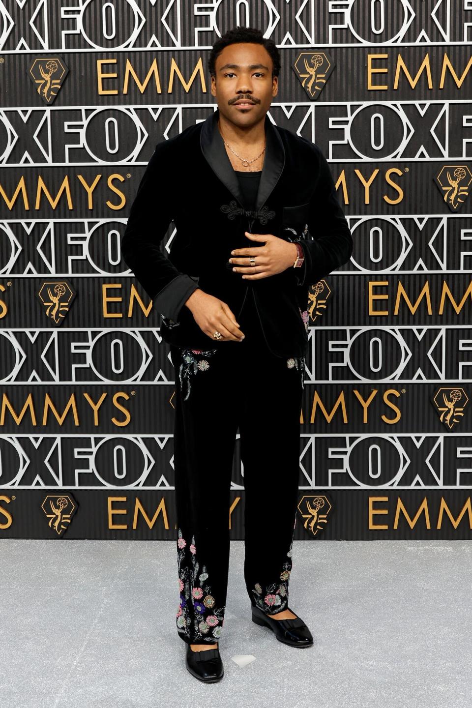 Atlanta creator and star Donald Glover wears a dark suit with wide lapels, floral details and loafers.