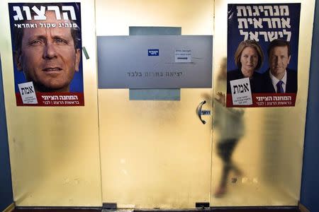 Election campaign posters depicting Tzipi Livni and Isaac Herzog, heads of the centrist Zionist Union party, are seen at the party's headquarters in Tel Aviv March 11, 2015. REUTERS/Nir Elias