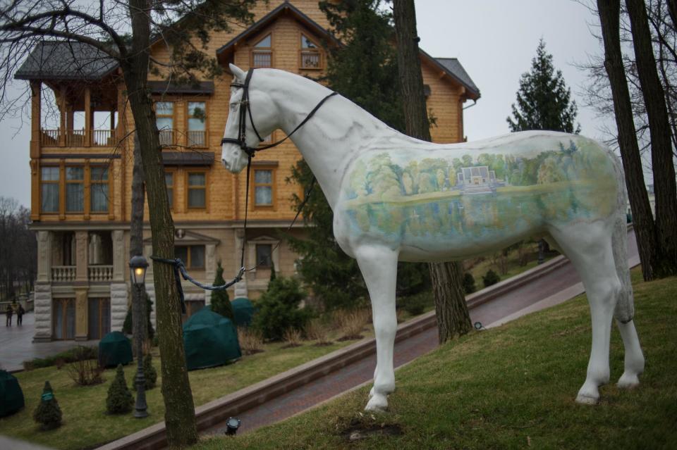 Un caballo decora la entrada de la residencia campestre del presidente ucraniano Viktor Yanukovych en Mezhyhirya, región de Kiev, Ucrania, el sábado 22 de febrero de 2014. Numeroso público pudo entrar al lujoso complejo de edificios después que Yanukovich huyó de Kiev. (Foto AP/Andrew Lubimov)