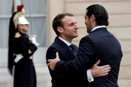 French President Emmanuel Macron and Saad al-Hariri, who announced his resignation as Lebanon's prime minister while on a visit to Saudi Arabia, embrace in the courtyard of the Elysee Palace in Paris, France, November 18, 2017. REUTERS/Benoit Tessier