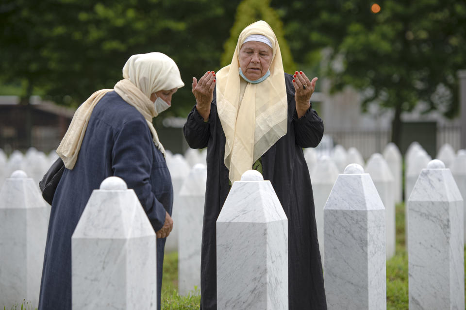 A woman prays at the memorial cemetery in Potocari, near Srebrenica, Bosnia, Tuesday, July 7, 2020. A quarter of a century after they were killed in Sreberenica, eight Bosnian men and boys will be laid to rest Saturday, July 11. Over 8,000 Bosnian Muslims perished in 10 days of slaughter after the town was overrun by Bosnian Serb forces in the closing months of the country’s 1992-95 fratricidal war. (AP Photo/Kemal Softic)