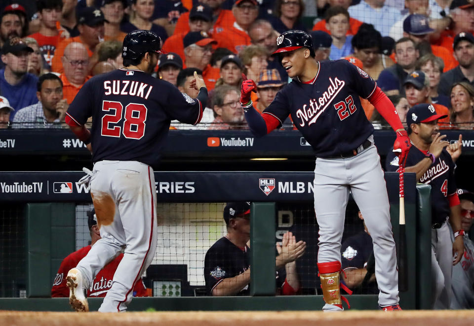 HOUSTON, TEXAS - OCTOBER 22:  Kurt Suzuki #28 of the Washington Nationals is congratulated by his teammate Juan Soto #22 after scoring a run on a hit by Adam Eaton (not pictured) against the Houston Astros during the fifth inning in Game One of the 2019 World Series at Minute Maid Park on October 22, 2019 in Houston, Texas. (Photo by Elsa/Getty Images)