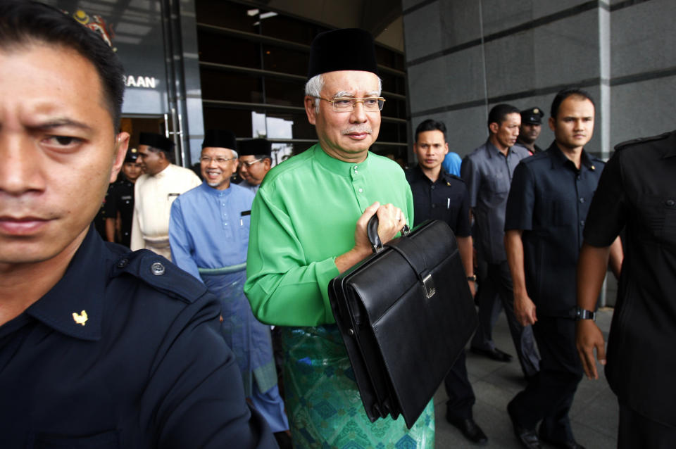 Malaysian Prime Minister and Finance Minister Najib Razak, center, holding a briefcase as he leaves from Finance Ministry office in Putrajaya, Malaysia, Friday, Sept. 28, 2012, to Parliament House to unveil the Malaysia's 2013 budget. (AP Photo/Lai Seng Sin)