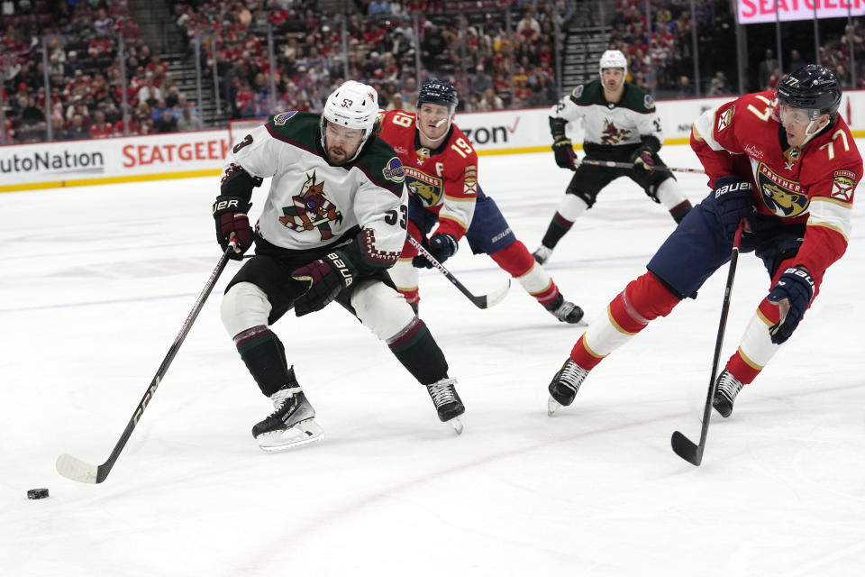 Arizona Coyotes left wing Michael Carcone (53) skates with the puck as Florida Panthers defenseman Niko Mikkola (77) defends during the first period of an NHL hockey game Wednesday, Jan. 24, 2024, in Sunrise, Fla. (AP Photo/Lynne Sladky)