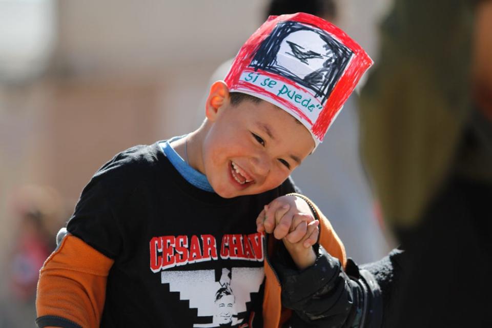 Students from grades pre-K to third of La Fe Preparatory School march through the Segundo Barrio in celebration of César Chávez Day on Friday. Students waved United Farm Workers flags and chanted, “Si se puede.”