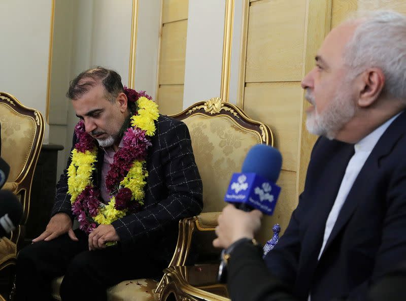 Iranian professor Massoud Soleimani sits next Iran's Foreign Minister Mohammad Javad Zarif during his arrival at Mehrabad airport, in Tehran