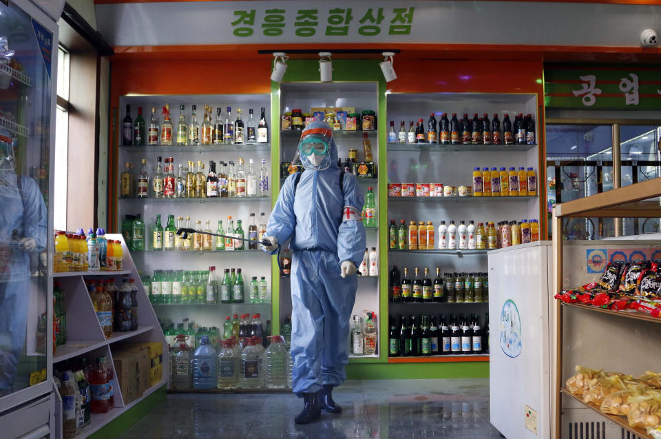 FILE - An employee of the Kyonghung Foodstuff General Store disinfects the showroom in Pyongyang, North Korea, Wednesday, Nov. 10, 2021. Before acknowledging domestic COVID-19 cases, Thursday, May 12, 2022, North Korea spent 2 1/2 years rejecting outside offers of vaccines and steadfastly claiming that its superior socialist system was protecting its 26 million people from “a malicious virus” that had killed millions around the world. (AP Photo/Jon Chol Jin, File)