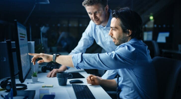 Two traders consult each other on some after-hours trades.