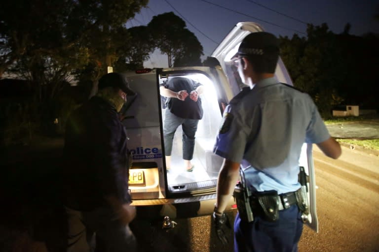 Police detain a suspect in the back of a police van, in Sydney, early morning of October 7, 2015