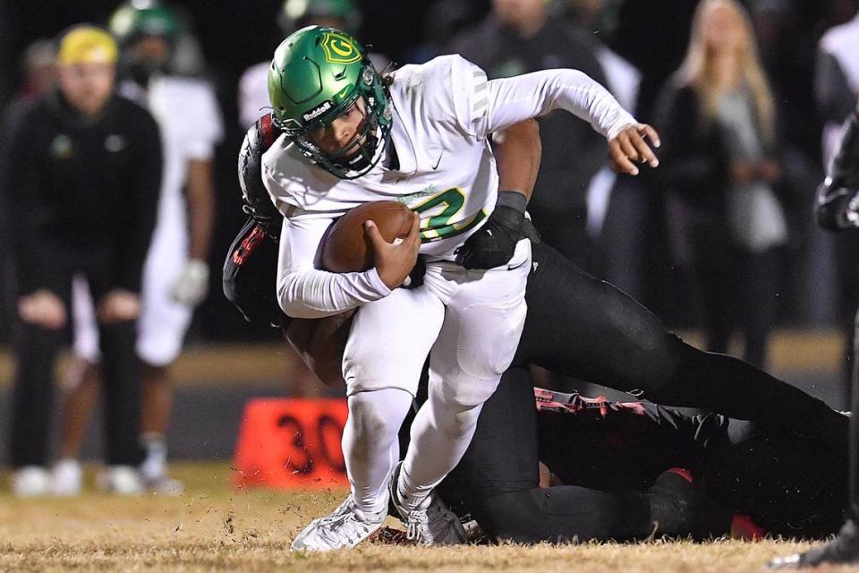 Cardinal Gibbons quarterback Gannon Jones (12) runs for yardage against Rolesville’s Russell Sykes (9) during the second half. The Rolesville Rams and the Cardinal Gibbons Crusaders met in the fourth round of the NCHSAA 4A Football Playoffs in Raleigh, N.C. on November 24, 2023.